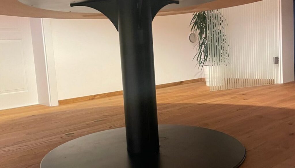 Metallteile für Tischler: Tischgestell aus Stahl mit Mittelsäule und runder Bodenplatte unter einer Holzplatte